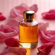 Small bottle of Bulgarian Rose Oil with fresh rose petals